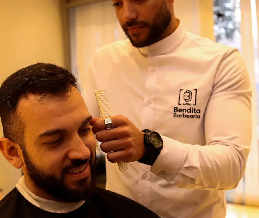 Barbeiro de uniforme Bendita atendendo cliente sorridente